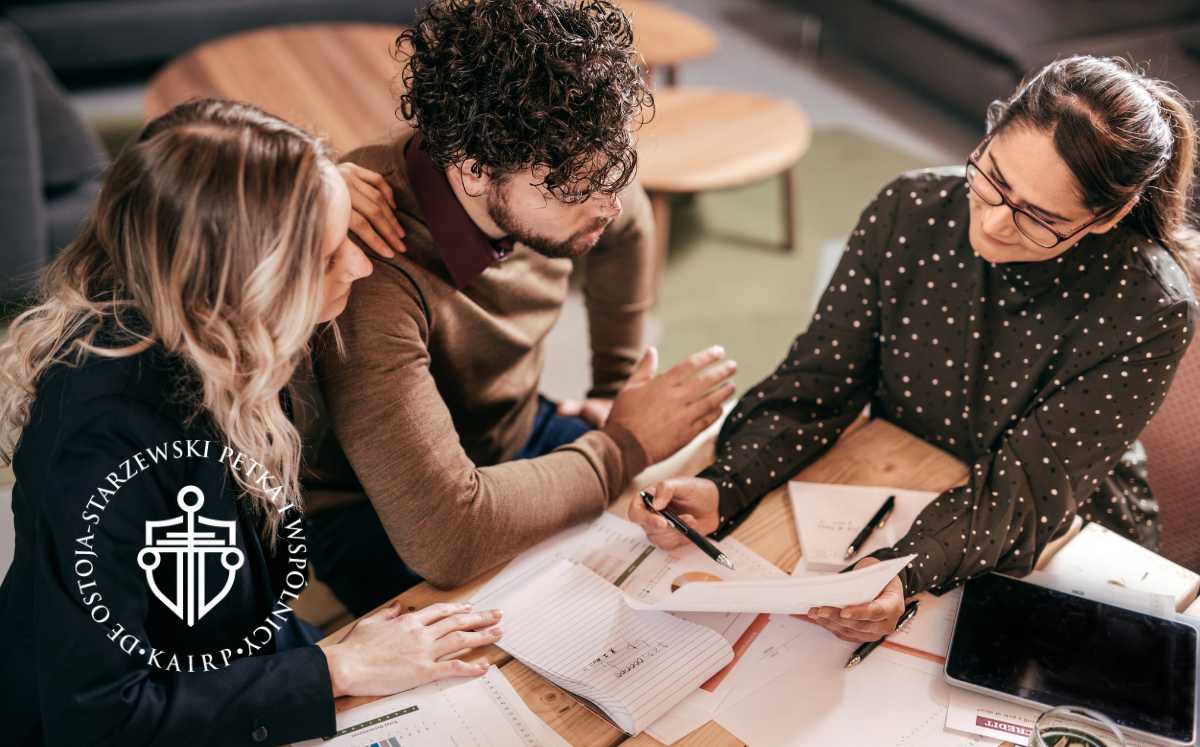 Trójka osób analizuje dokumenty kredytowe przy stole, omawiając możliwości prawne.