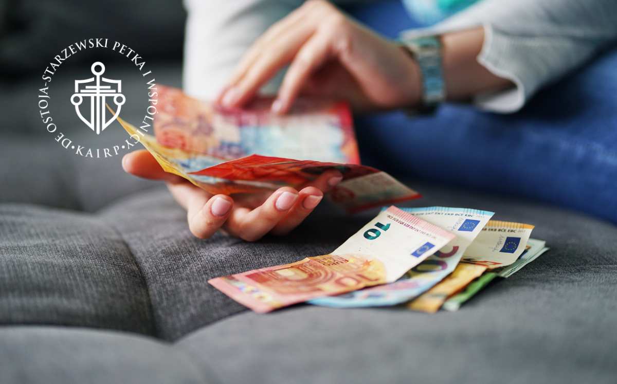 Osoba licząca kolorowe banknoty, symbolizujące potencjalne korzyści finansowe z ugody frankowej lub wyroku sądu