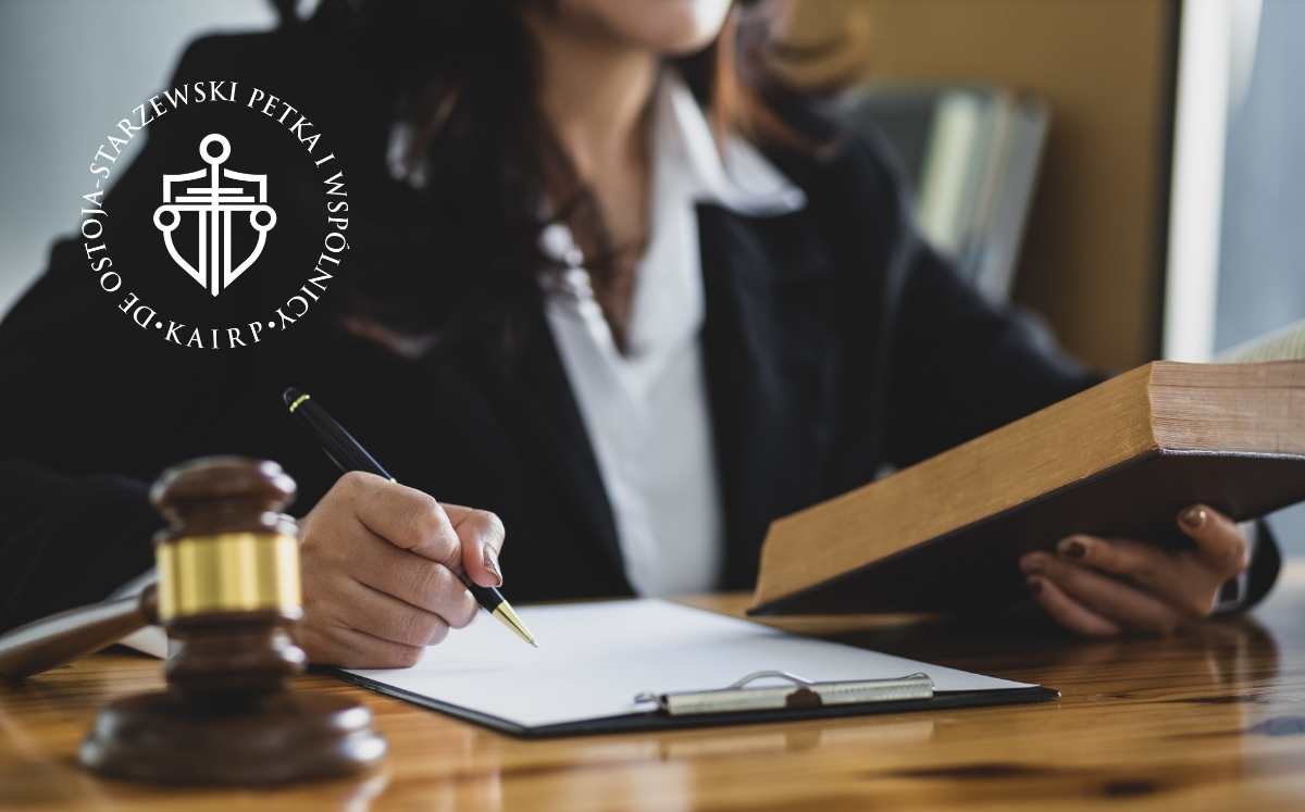 co-zrobic-po-otrzymaniu-pozwu-od-banku 1 Kobieta w todze prawniczej siedząca przy biurku, trzymająca książkę i podpisująca dokument. Obok leży młotek sędziowski, a w tle widoczne logo kancelarii „DE OSTOJA-STARZEWSKI PETKA I WSPÓLNICY”.