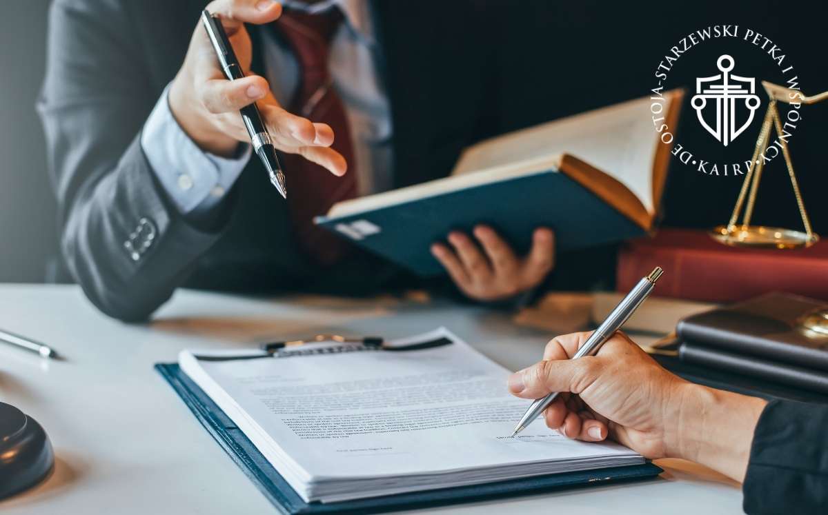 uniewaznienie-umowy-kredytu-dolarowego Dwóch prawników omawia dokumenty przy biurku, w tle książki prawnicze i waga sprawiedliwości – symbol kancelarii.
