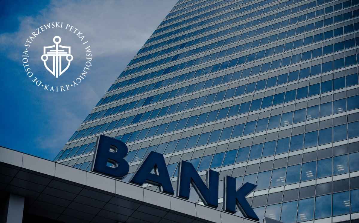 Wysoki, nowoczesny budynek biurowy z dużym napisem „BANK” na fasadzie.
