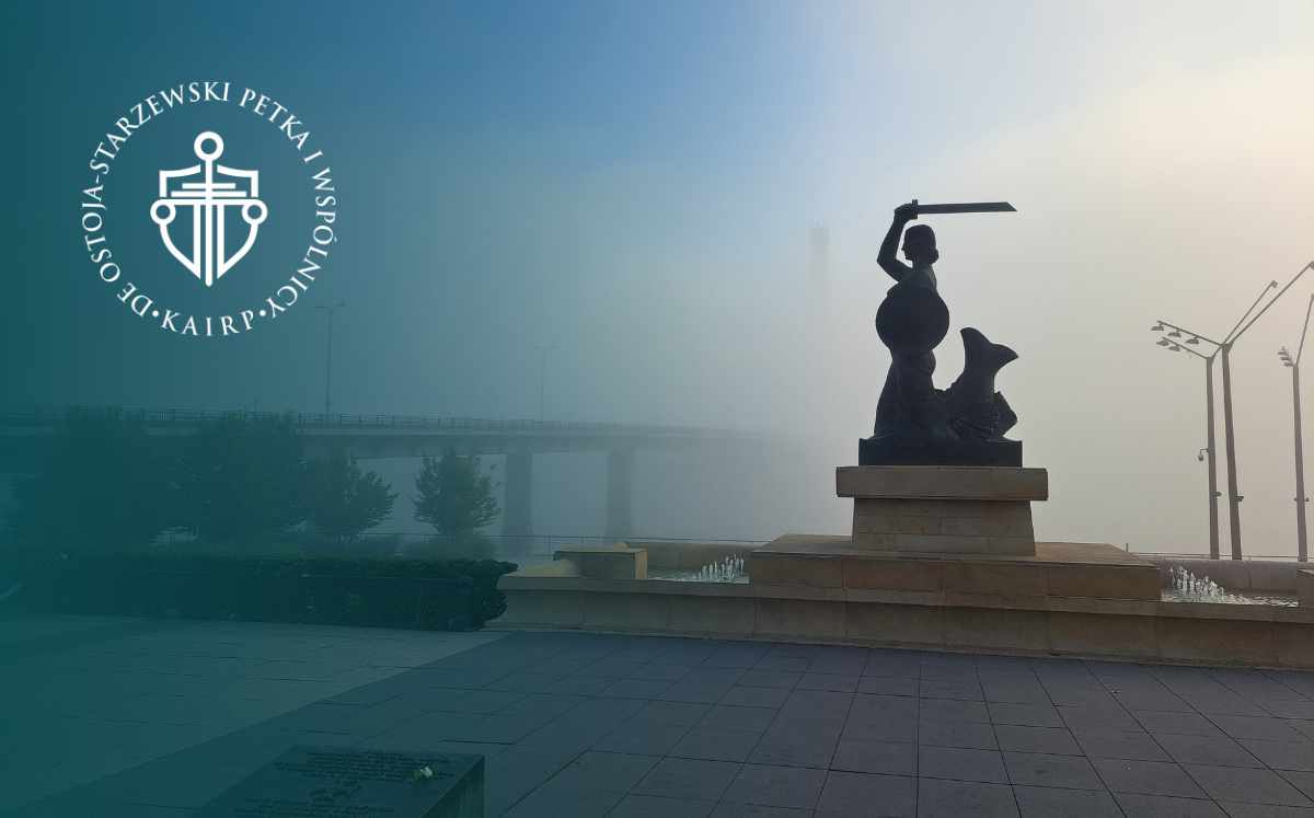 Pomnik Temidy z uniesionym mieczem na tle miejskiego placu i mostu, symbol wymiaru sprawiedliwości, z logo kancelarii prawnej.