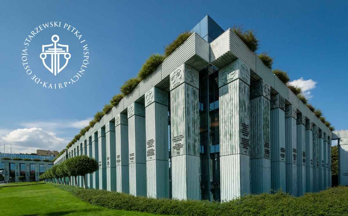 Nowoczesny budynek sądu z wysokimi kolumnami i roślinnością na dachu, na tle błękitnego nieba; po lewej stronie widoczne logo kancelarii Ostoja-Starzewski, Petka i Wspólnicy.