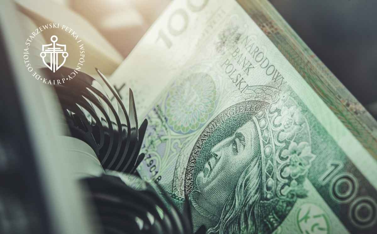 Zbliżenie na polski banknot 100 zł w liczarkce pieniędzy.