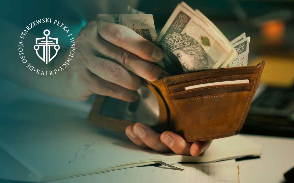 Ręka trzymająca portfel z banknotami – symbol rozliczeń finansowych i potrącenia w sprawach frankowych