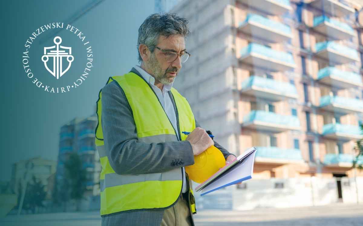 Inspektor budowlany w kamizelce odblaskowej sprawdzający dokumentację na placu budowy budynku mieszkalnego