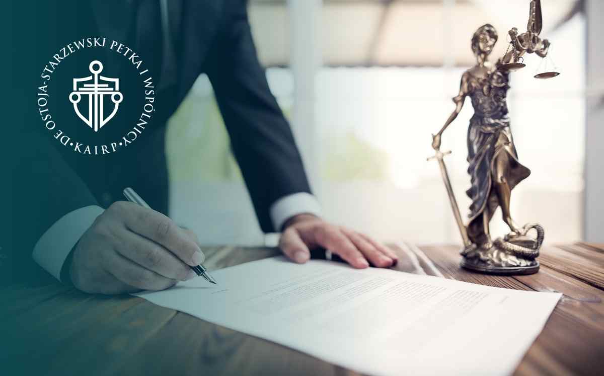 Prawnik podpisujący dokument przy figurze Temidy – formalności prawne związane ze służebnością przesyłu