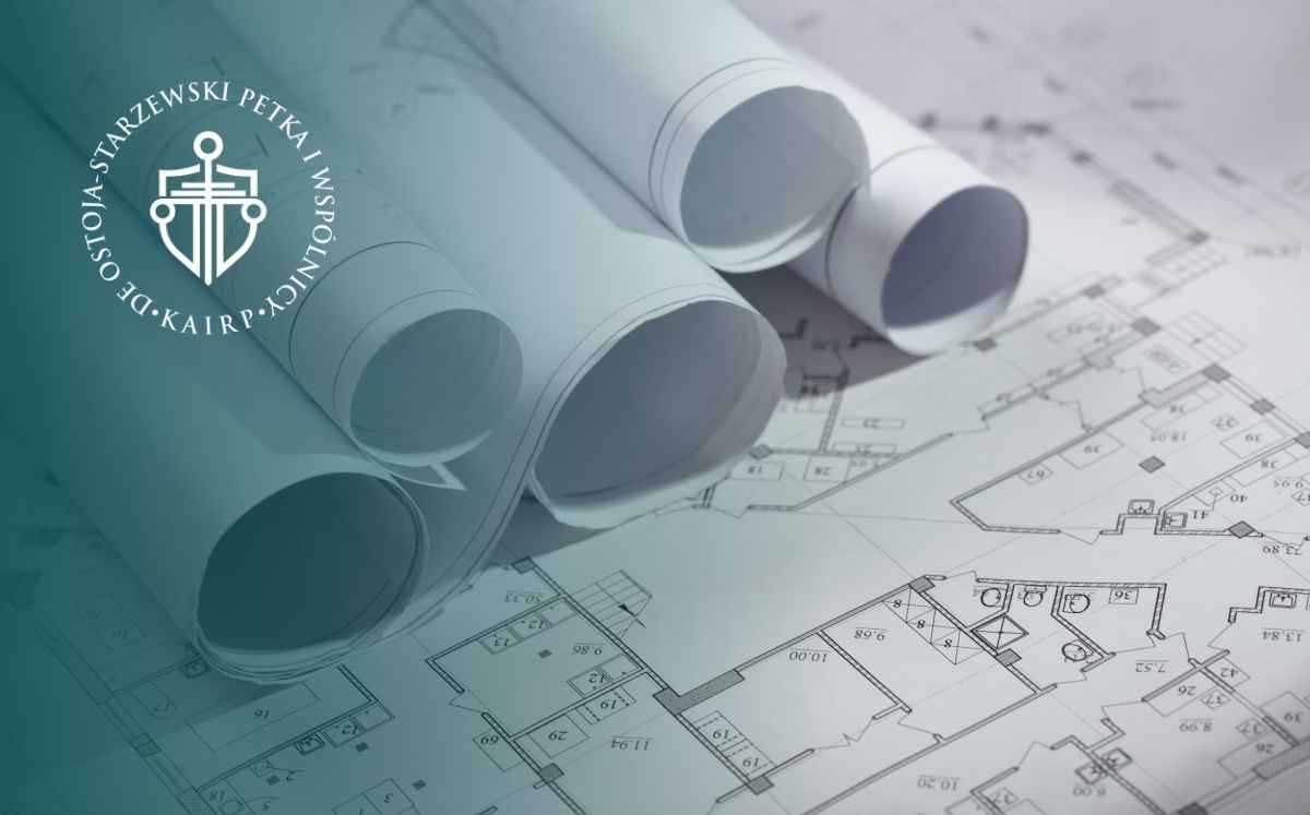Zwinięte projekty architektoniczne na planach technicznych budynku – dokumentacja projektowa inwestycji.