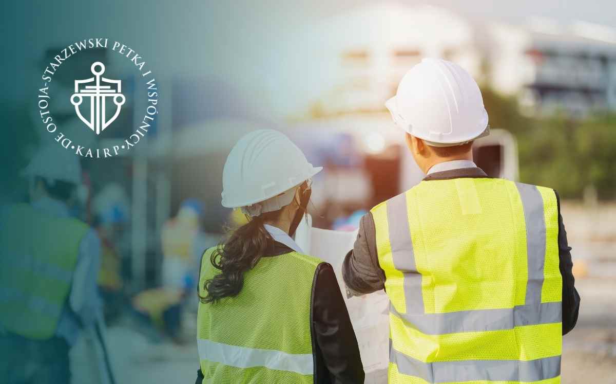 Dwóch inżynierów budowlanych w kaskach ochronnych analizujących plany na placu budowy – grafika dotycząca prawa budowlanego i odstąpienia od umowy o roboty budowlane.