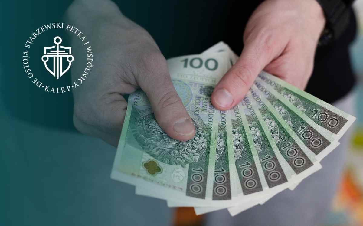 Ręce trzymające banknoty 100 zł – symbol finansów i rozliczeń związanych ze sprawami frankowymi Getin Noble Banku.