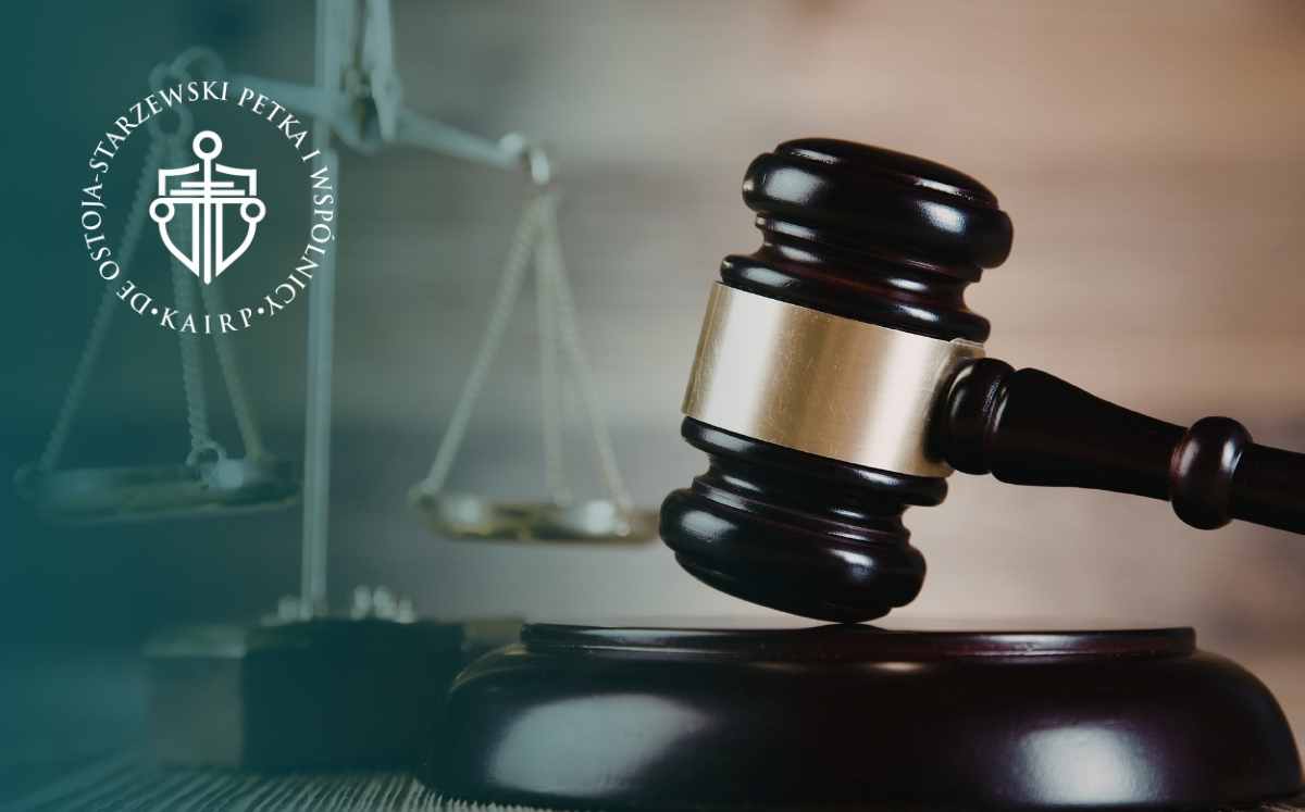 Młotek sędziowski na tle wagi sprawiedliwości – symbol prawa i orzecznictwa.