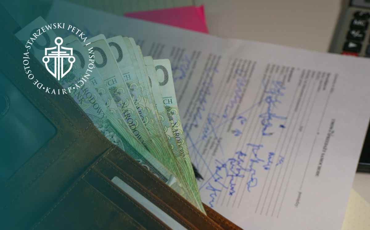 Portfel z banknotami oraz podpisywane dokumenty kredytowe – symbol kosztów i formalności związanych z kredytem.