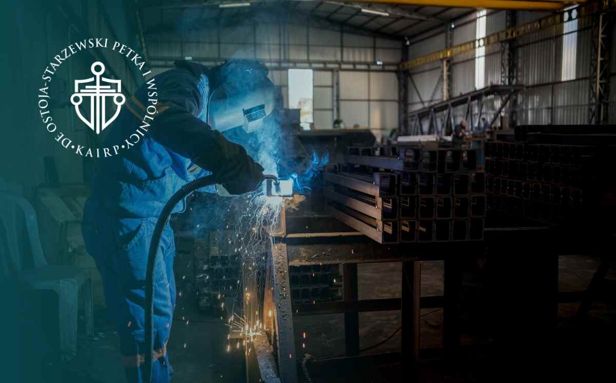 Pracownik spawający metalowe elementy w hali produkcyjnej, nawiązanie do ryzyka wypadku przy pracy i odszkodowania z ZUS.