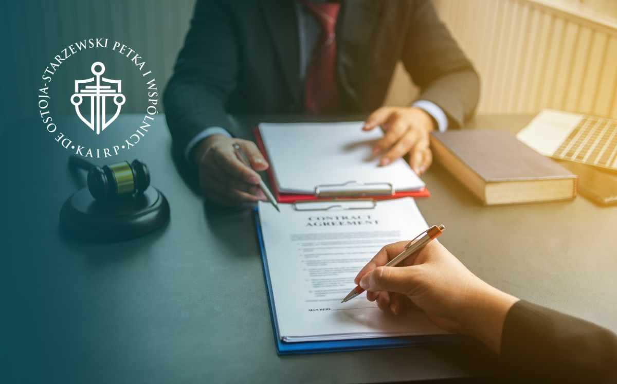 Two professionals sign a legal document at a desk, with a gavel and books nearby and a circular logo on the left side of the image with legal symbols.