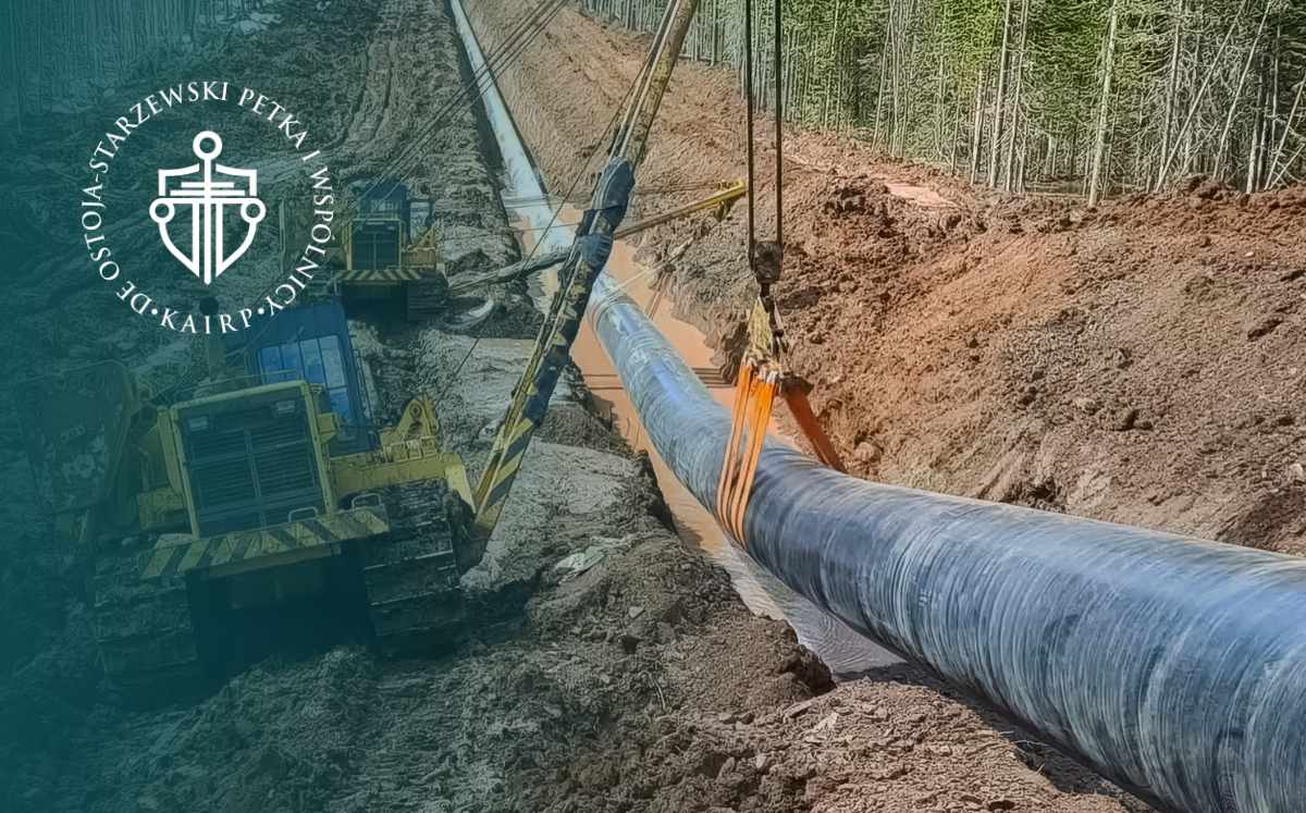 Prace budowlane przy układaniu gazociągu w wykopie na terenie leśnym, związane z infrastrukturą przesyłową.