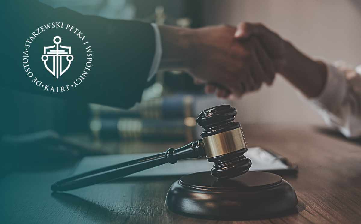 Handshake over a wooden desk with a gavel in the foreground and a circular law logo on the left, suggesting a legal agreement or deal.