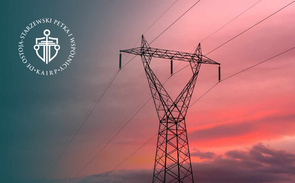 High-voltage power transmission tower at sunset with a circular white logo on the left.