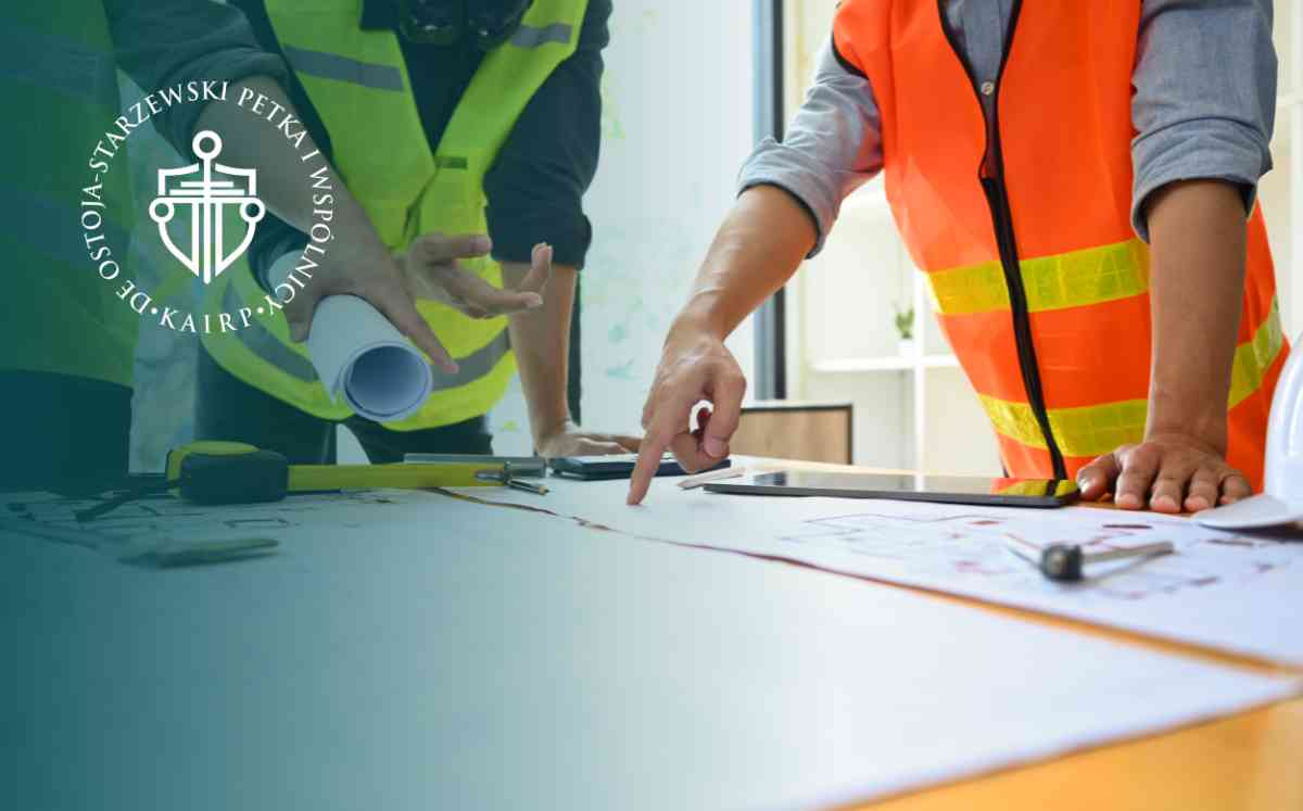 grafika przedstawia dwóch pracowników budowlanych nad projektem budowy