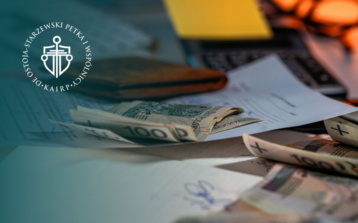 Banknoty leżące na stole. Obok nich porozkładane dokumenty i portfel