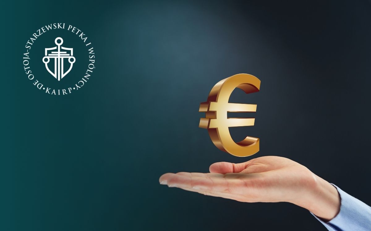 ikona euro leżąca na dłoni na tle jednolitego ciemnego tła
