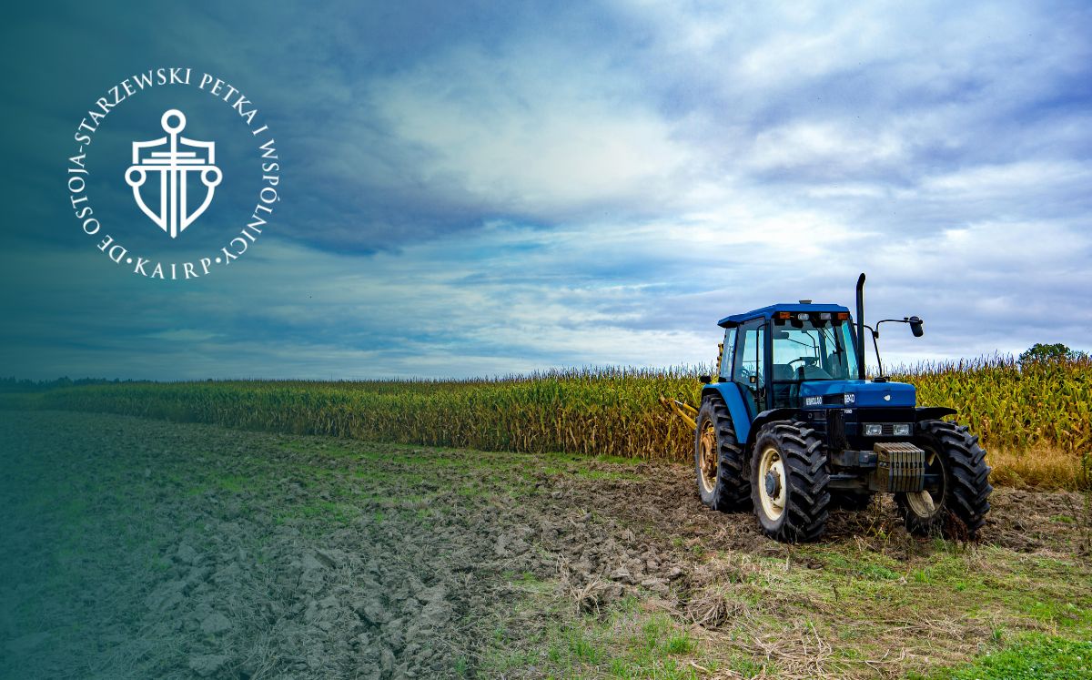 Niebieski traktor stoi w lewym rogu na tle pola